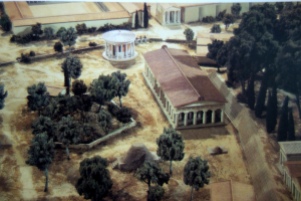 Reconstruction of the NW part of the sanctuary of Olympia. The Philippeion, in the middle, is flanked by the temple of Hera (to the right), the pentagon enclosing the tomb of the hero Pelops (to the left) and the great altar of Zeus (in the front). Image source [2]